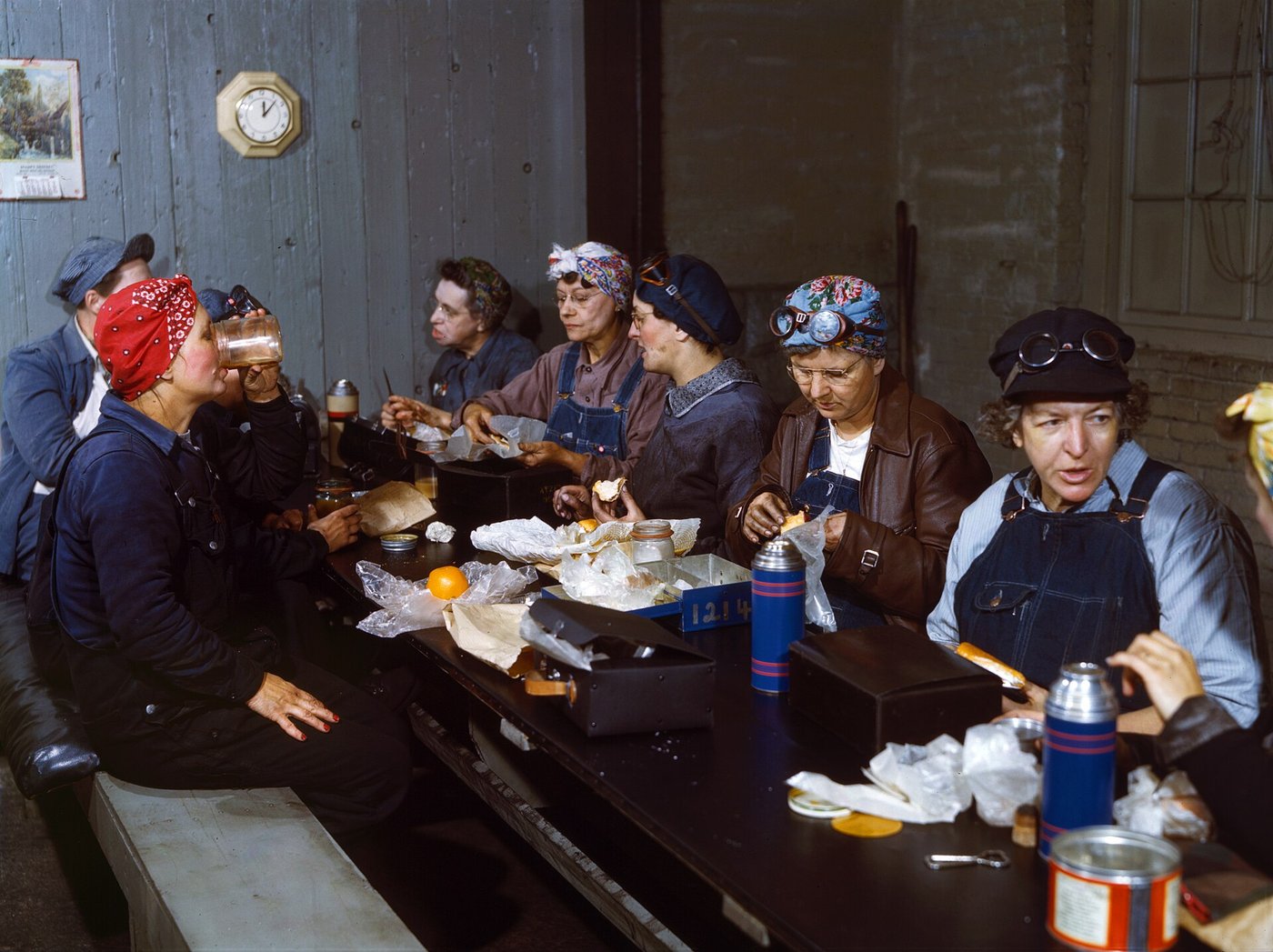A crew of women railroad workers eating lunch together at a long table